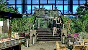 Een restaurant met terras, een grill en een trap naar een hoger gelegen niveau.