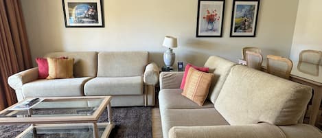 A living room with two sofas, a coffee table, a lamp, and framed artwork on the wall.