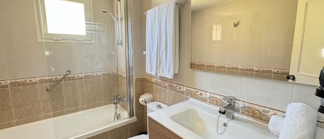A modern bathroom with a bathtub, shower, toilet, and sink.