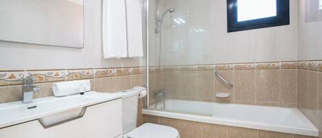 A bathroom with a shower, toilet, sink, and bathtub.