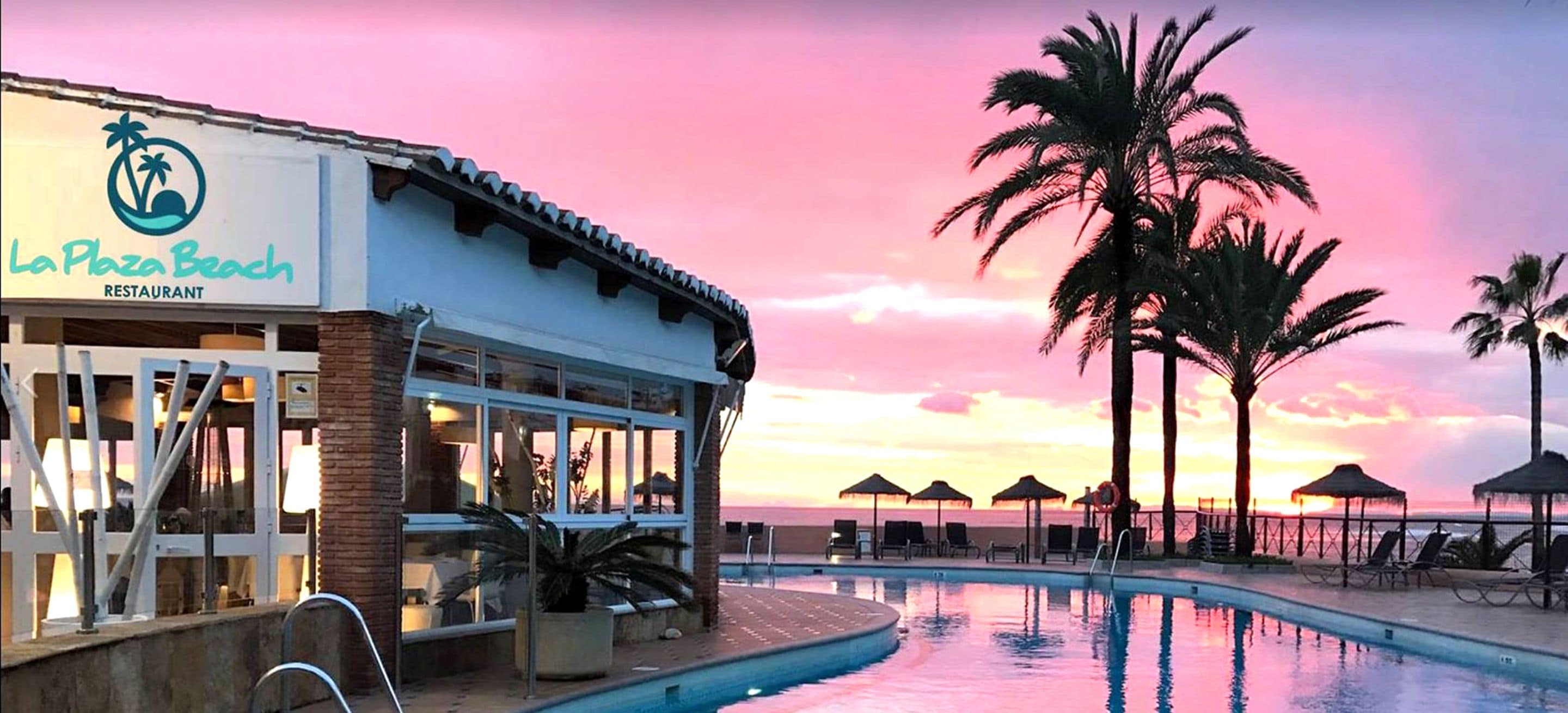 A poolside area with lounge chairs and umbrellas, a restaurant named "La Plaza Beach Restaurant," and a sunset view.