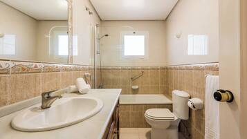 A bathroom with a sink, toilet, and bathtub.