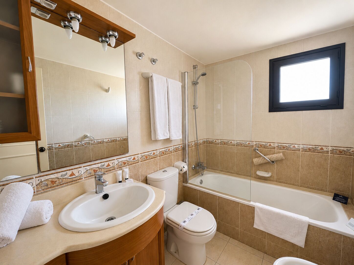 Une salle de bain équipée d’un lavabo, de toilettes, d’une baignoire et d’une douche.