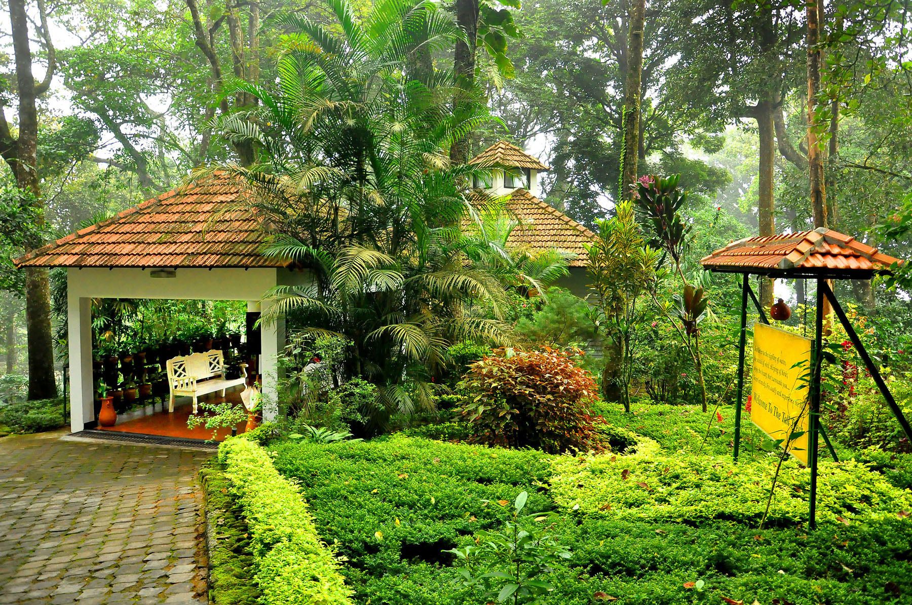 A garden with a gazebo, potted plants, and a pathway.