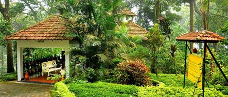 A garden with a gazebo, potted plants, and a pathway.