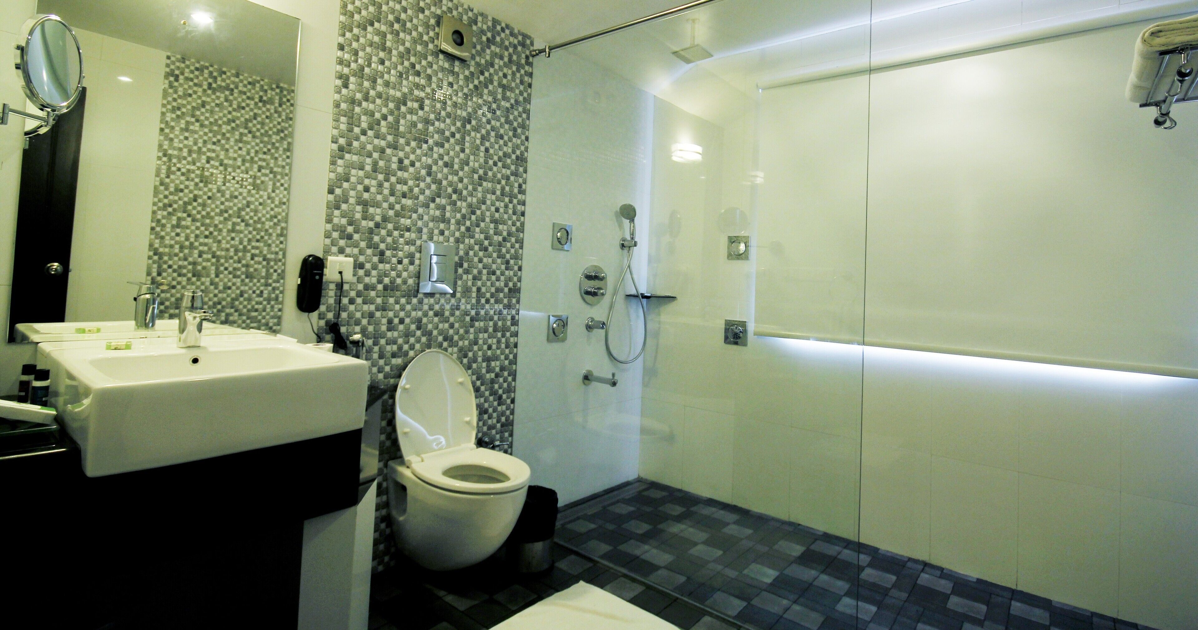 A modern bathroom with a sink, toilet, and shower.
