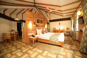 A bedroom with a wooden bed, a desk, a chair, and a television.