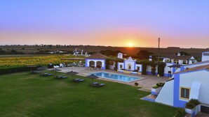 A villa with a swimming pool, outdoor seating, and a view of the sunset. - Herdade Do Touril (Odemira)