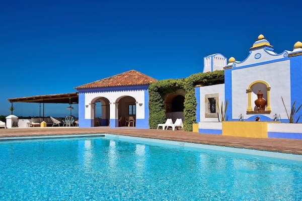 Una piscina al aire libre, sillones reclinables de piscina