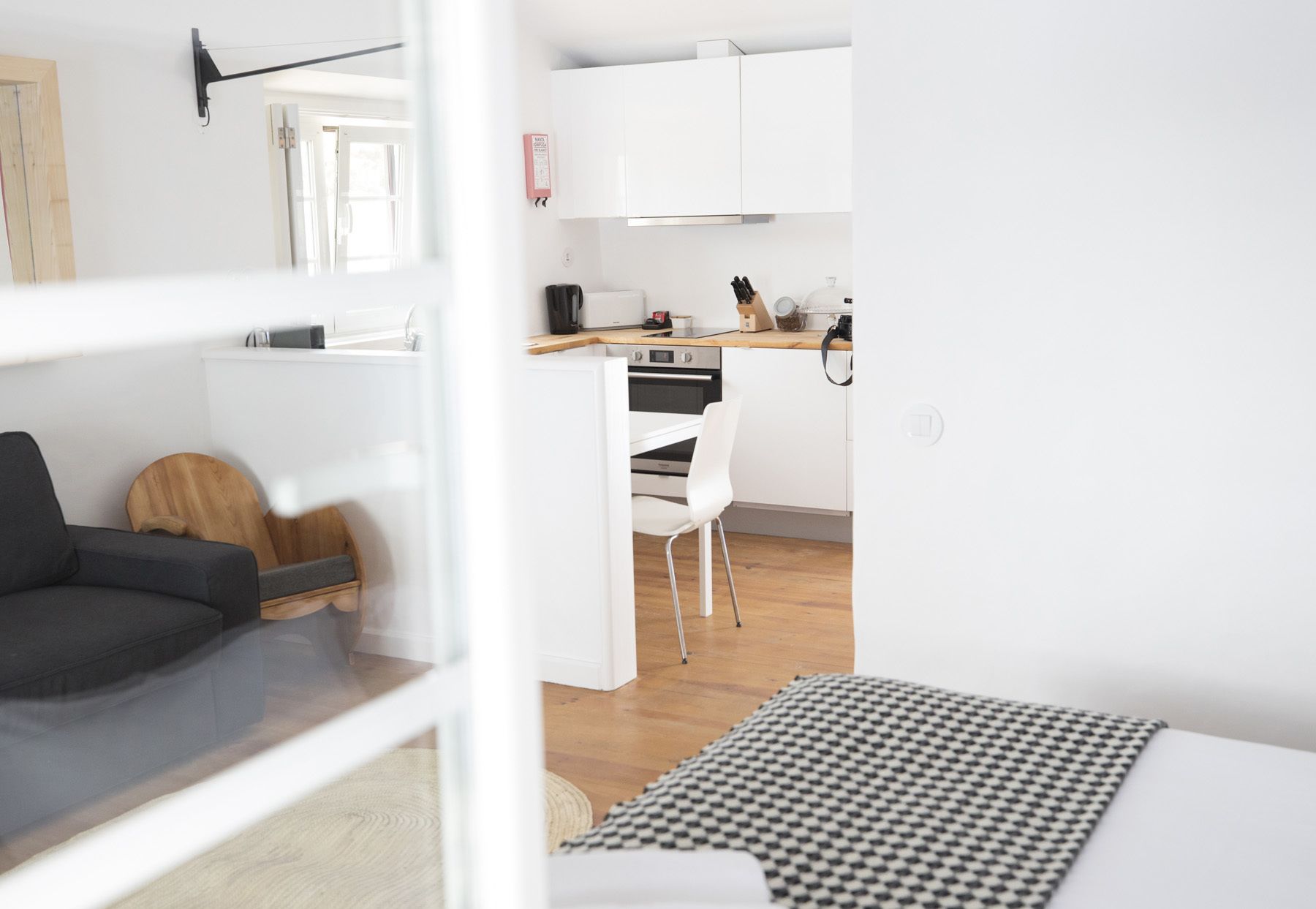 Un espacio habitable moderno y funcional con kitchenette, zona de comedor y sofá.