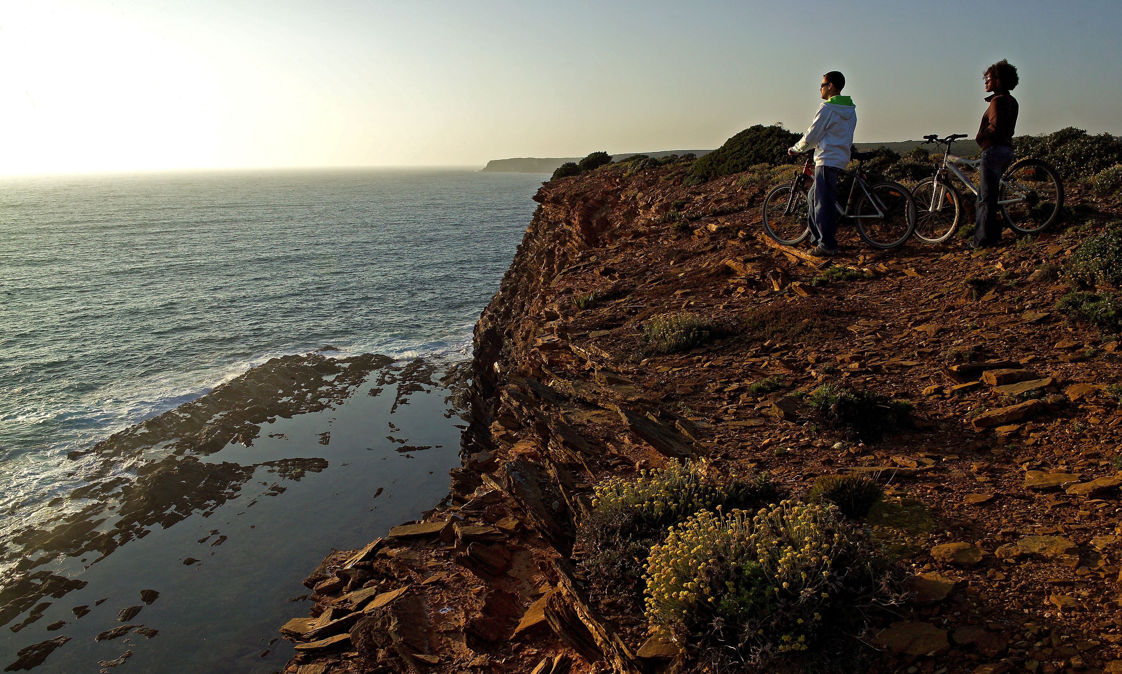 A coastal landscape with rocky terrain and a view of the sea.