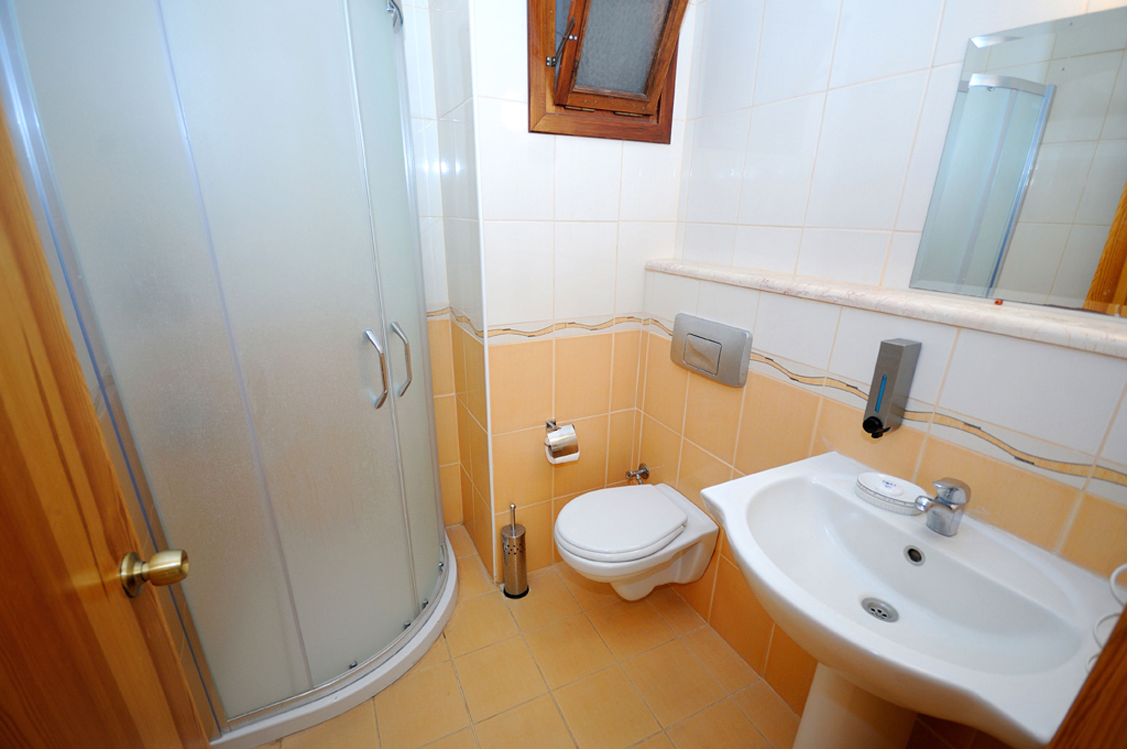 Une salle de bain avec douche, toilettes et lavabo.