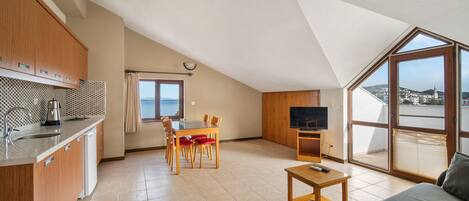 A compact living space with a kitchenette, dining area, and a sofa.