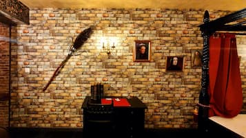 A room with a brick wall, a feather quill, a black cabinet, and a red curtain.
