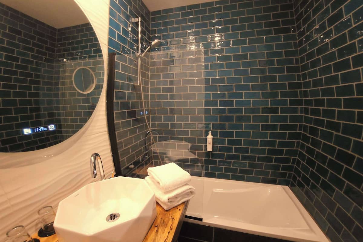 deluxe triple room | bathroom | bathtub, designer toiletries, hair dryer, towels