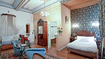Um quarto com uma cama, uma cadeira, uma penteadeira e um guarda-roupa.
