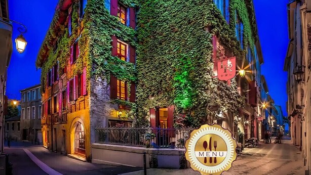 A building with ivy-covered facades and illuminated windows, suggesting a historic or boutique hotel setting.