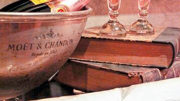 A bucket labeled "MOET & CHANDON" with champagne bottles and glasses, placed on a table with a book and sheet music titled "MÉLODIE ROMANTIQUE" by Alfred Jaell.
