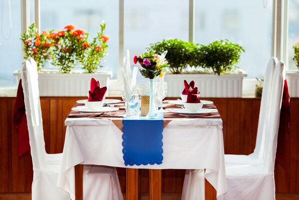 A dining table set with white tablecloths, blue runner, and red napkins. - Danang Pacific Hotel (Da Nang)