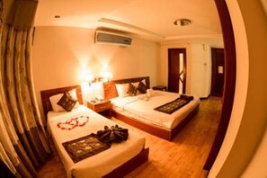 A hotel room with two beds, a nightstand, a lamp, and an air conditioning unit. - Danang Pacific Hotel (Da Nang)