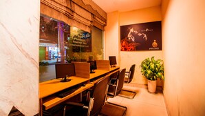 A hotel room with a wooden desk, multiple computer monitors, and a potted plant. - Danang Pacific Hotel (Da Nang)