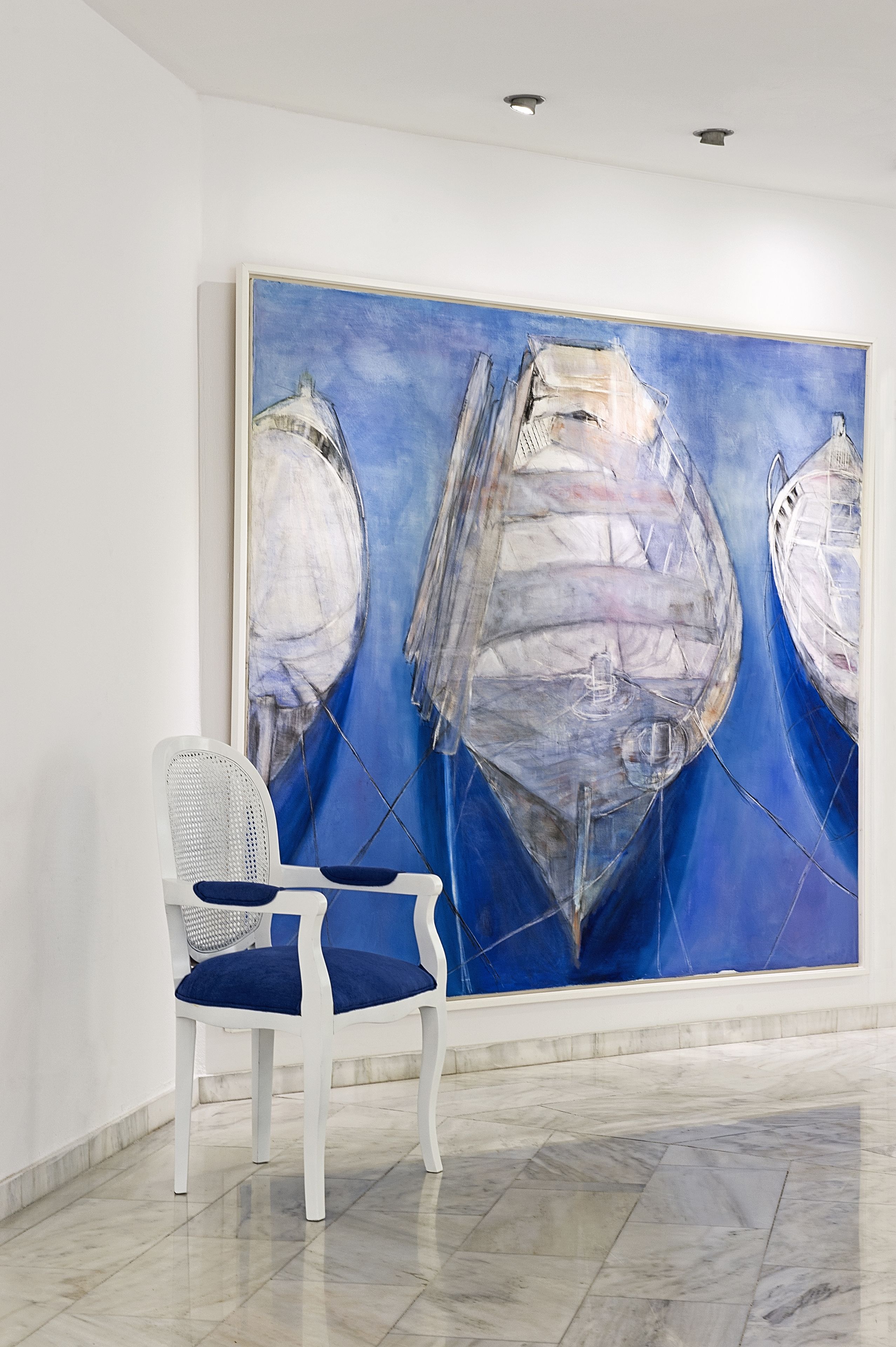 Una habitación con un cuadro abstracto grande en la pared, una silla blanca con cojines azules y un suelo de mármol.