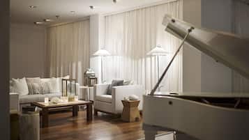 A modern living room with a piano, a sofa, a coffee table, and two floor lamps.