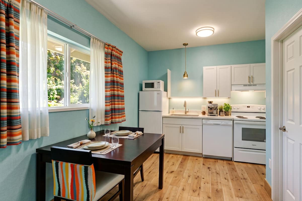 A compact kitchen with white cabinets, a microwave, a dishwasher, and a stove.