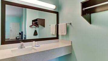A bathroom with a white sink, a large mirror, and a towel rack.