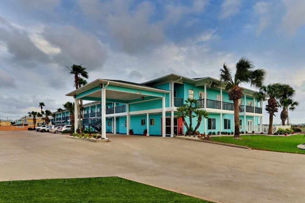 A two-story building with a covered front porch and multiple balconies.