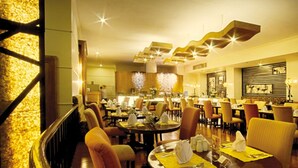 Un restaurante espacioso con varias mesas, asientos cómodos y una decoración de estilo moderno.