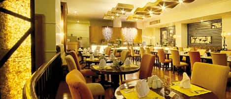 Un restaurante espacioso con varias mesas, asientos cómodos y una decoración de estilo moderno.