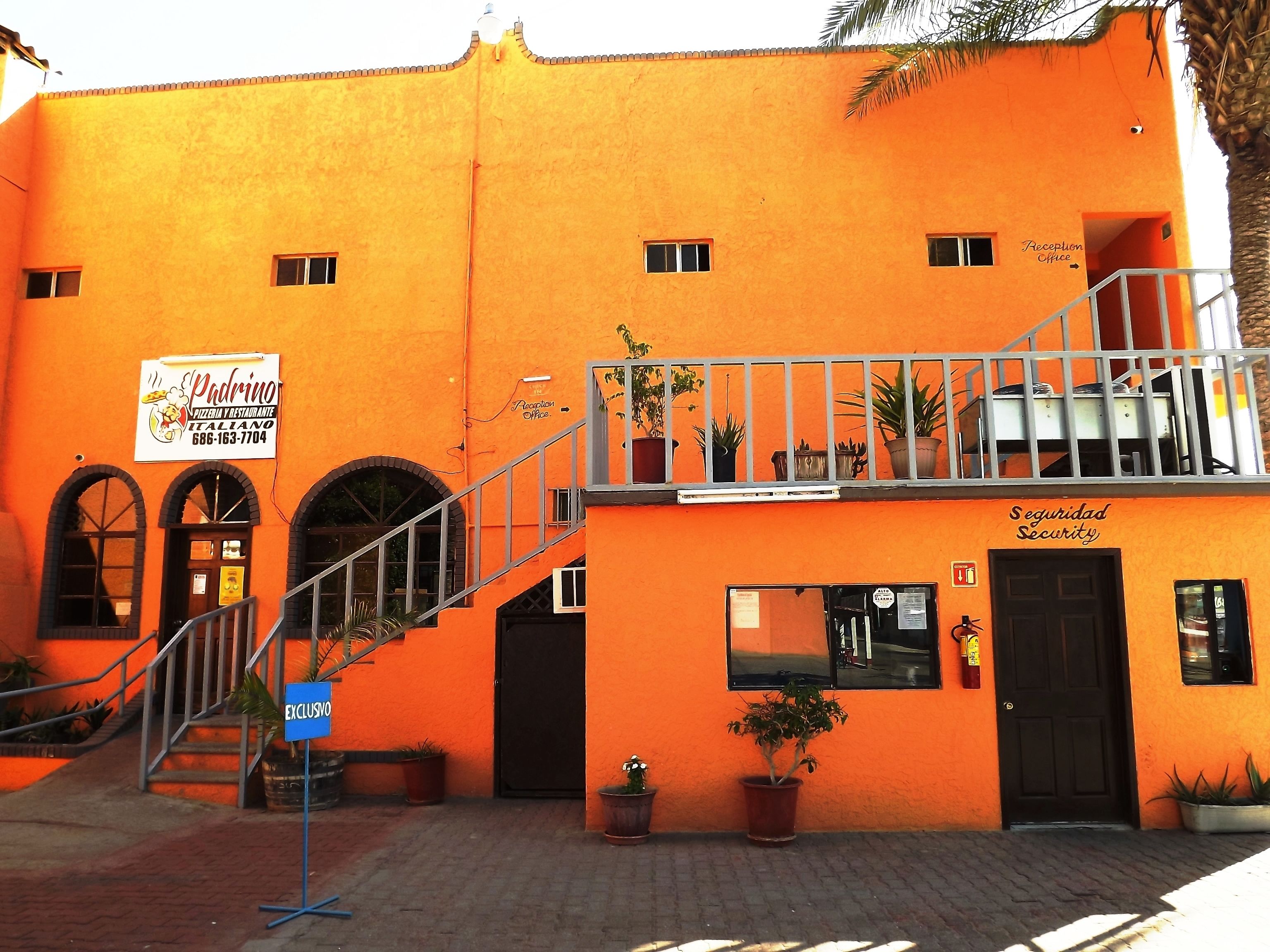 En bygning med en orange facade, en receptionsdisk og et sikkerhedskontor.