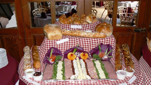 Una mesa de buffet con diferentes platillos y un mantel a cuadros.