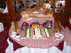Una mesa de buffet con diferentes platillos y un mantel a cuadros.