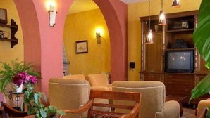 A cozy living room with wooden furniture, a television, and decorative lighting. - El Soto de Roma (Fuente Vaqueros)
