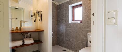 A modern bathroom with a shower, toilet, and vanity.