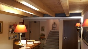 A staircase leading to a second floor, a desk with papers, a lamp, and a small table with a plant. - Hotel Capitelli (Trieste)