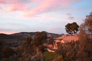A rural landscape with a house surrounded by trees and hills. - Masia La Mota (Alcoy)
