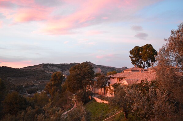 A rural landscape with a house surrounded by trees and hills. - Masia La Mota (Alcoy)