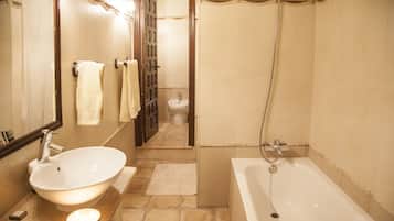 A bathroom with a sink, mirror, towel rack, shower, and toilet.