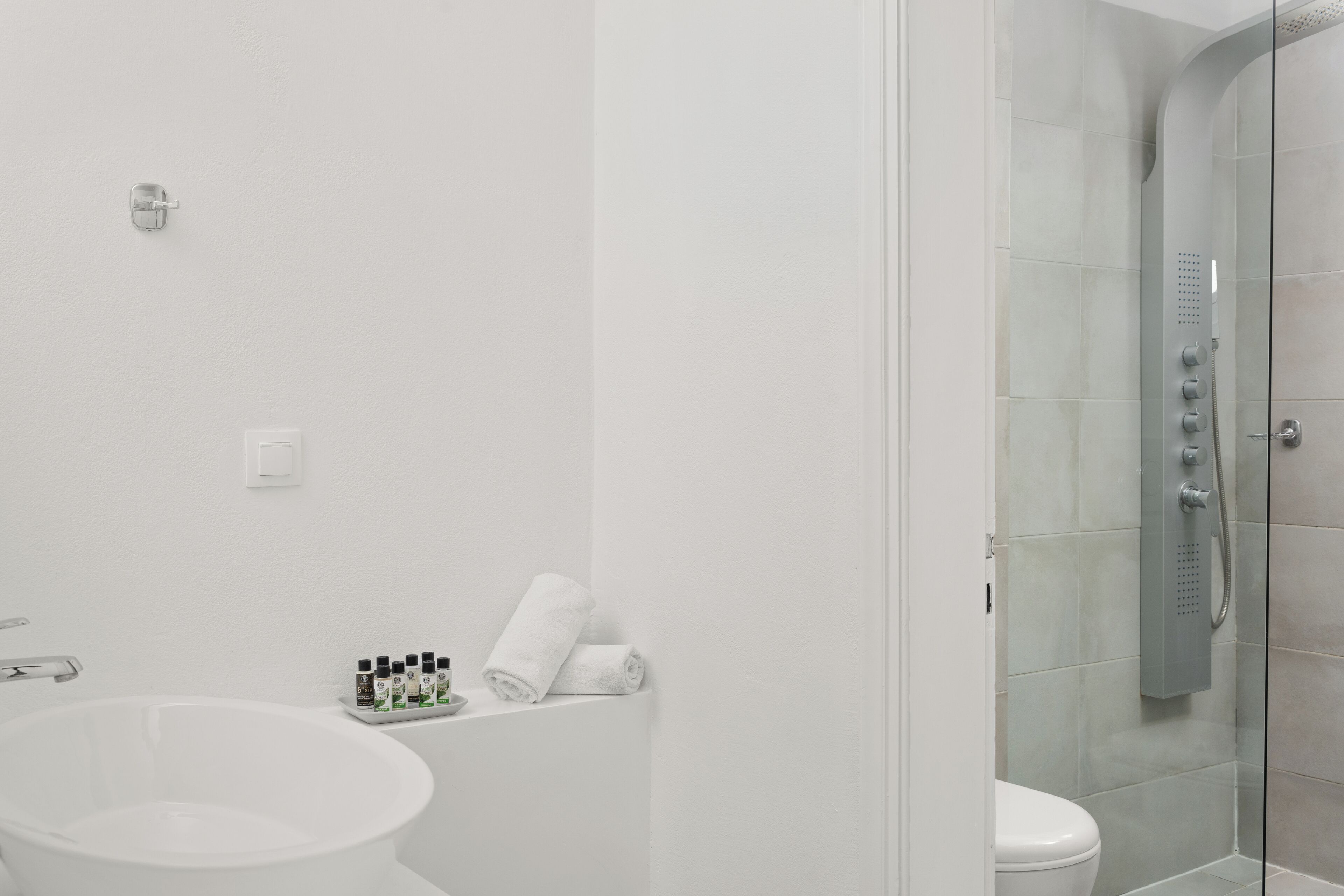 Un baño moderno con una bañera independiente, un inodoro y zona de ducha con mampara de vidrio.