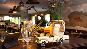 A bar area with a laptop, a vintage car model, a clear glass pitcher, and a potted lavender plant. - Penzión Berg (Bratislava)