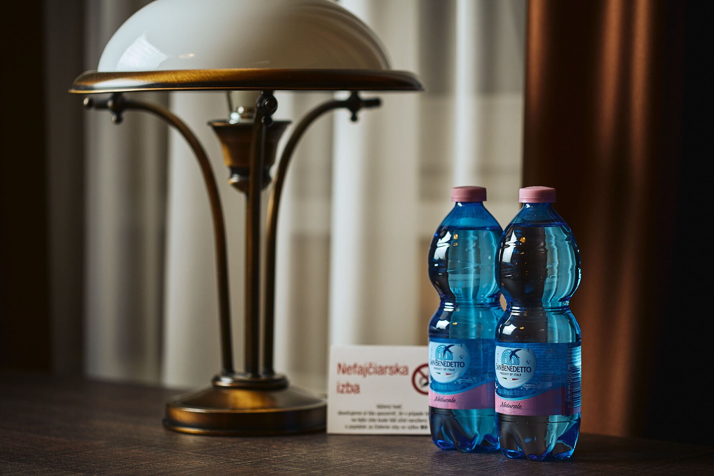 Una mesa con una lámpara y dos botellas de agua.