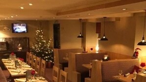 A restaurant with multiple dining tables set for guests, each with neatly folded napkins and cutlery. - Nithsdale Hotel (Sanquhar)