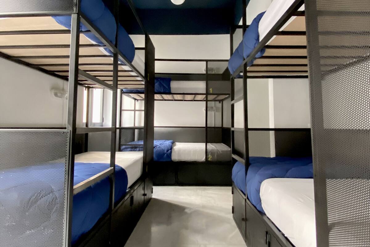 A bunk bed room with metal railings and a white ceiling.