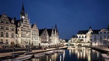 A historic canal with boats docked, surrounded by traditional European architecture.
