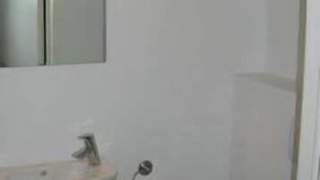 A bathroom with a white sink, a mirror, and a toilet.
