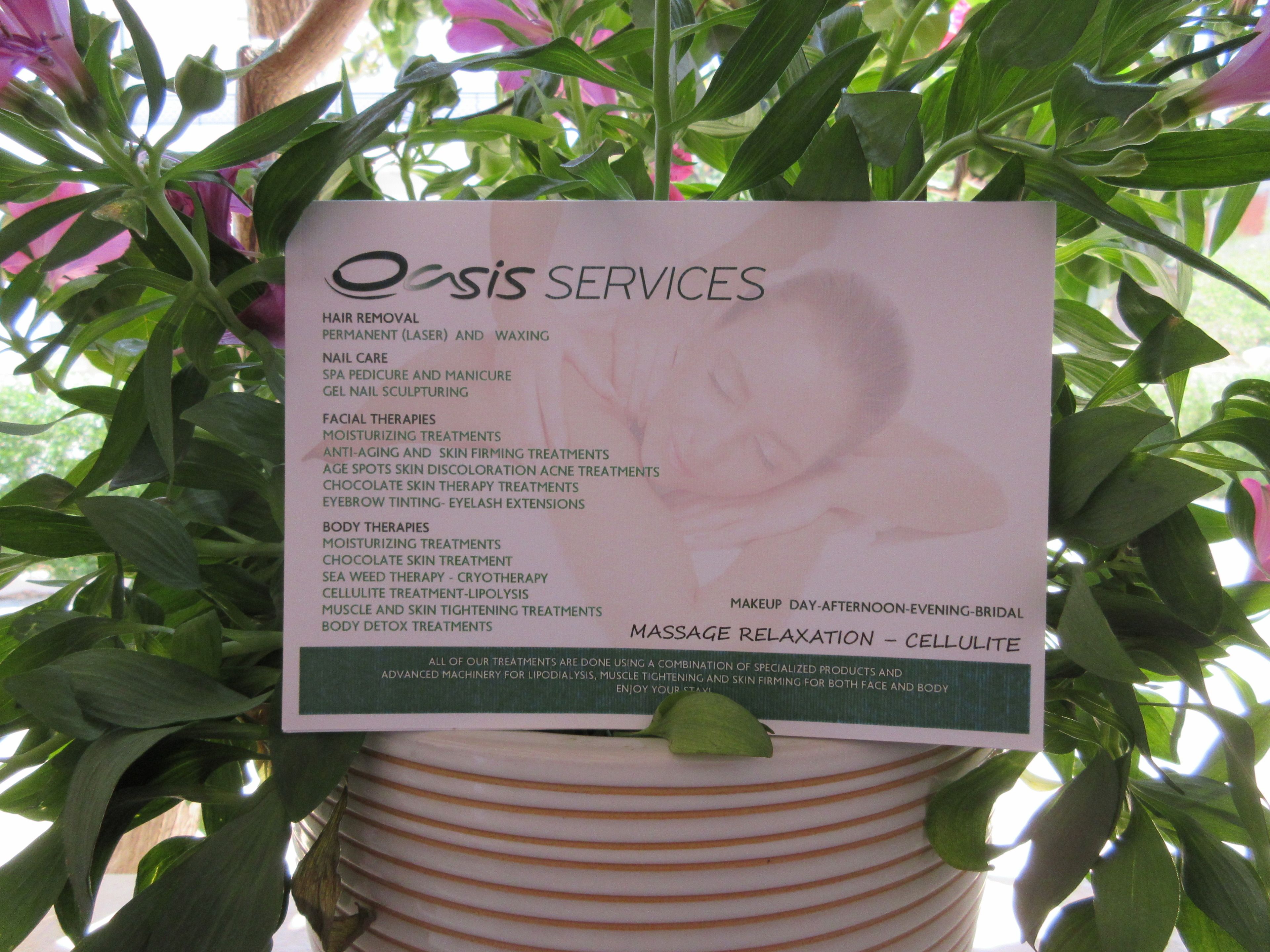 A sign listing Oasis Services' offerings, including hair removal, nail care, and various treatments.
