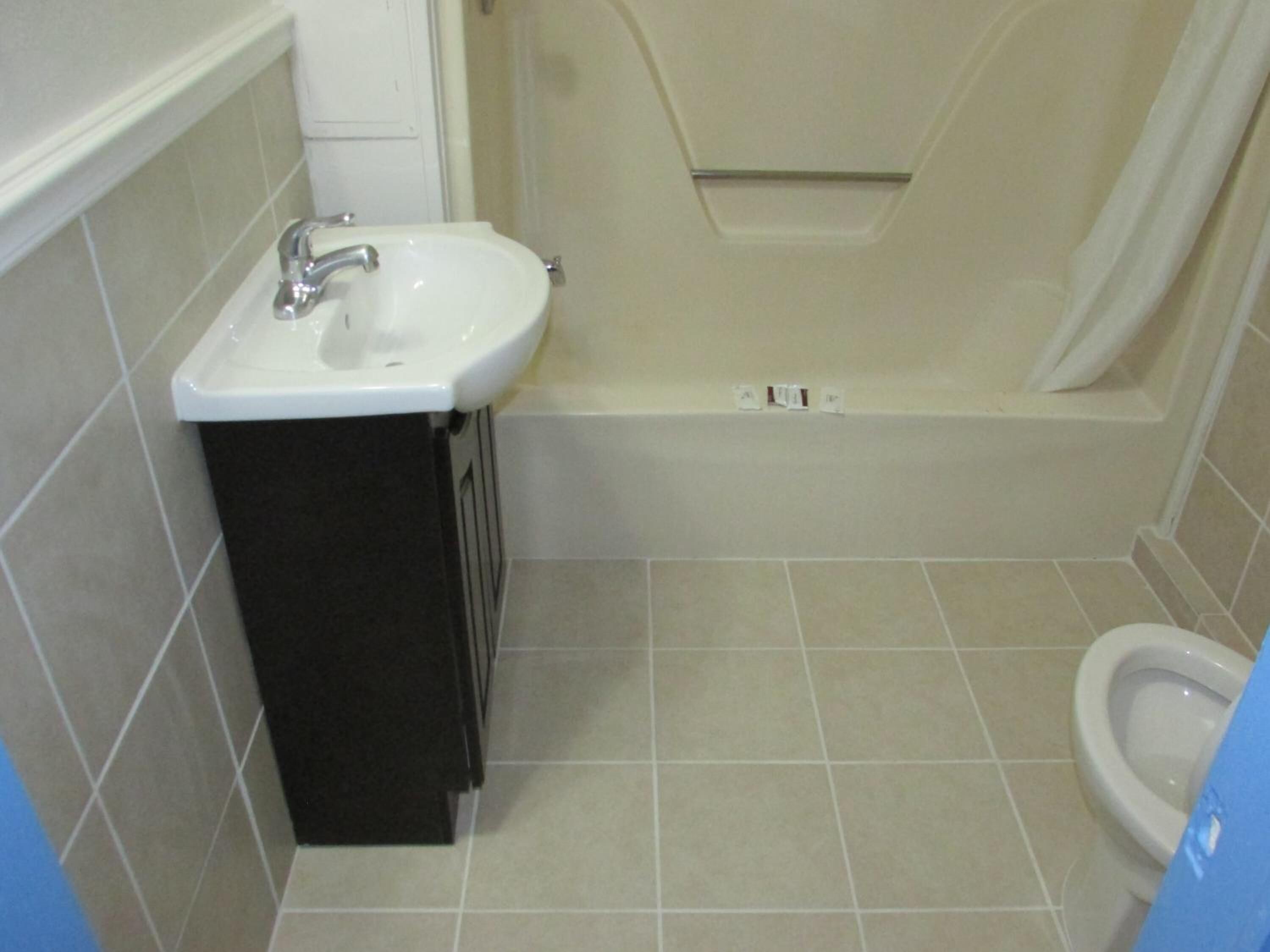 A bathroom with a sink, toilet, and bathtub.